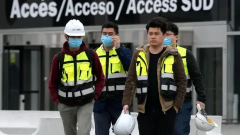 Getty Images Workers leave the Mobile World Congress venue in Barcelona.