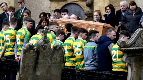 PA Members of St Malachy's Edendork GAC, who Connor Currie played for, flank his coffin