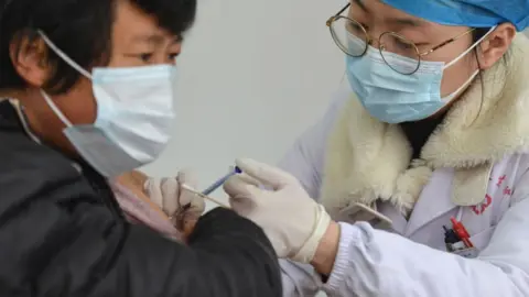 Getty Images A medical worker vaccinates a rural resident at a COVID-19 vaccination site at the township level in Fuyang.