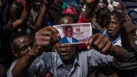 AFP Opposition supporters demonstrate with a fake money with the face of presidential candidate Raila Odinga prior to his mock 'swearing-in' on January 30, 2018 at Uhuru Park in Nairobi, Kenya