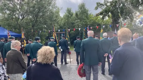 Survivors and families laying wreaths at service in Ballygawley