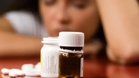 Getty Images woman with pill bottle