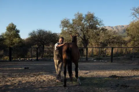 Erica Canepa Oscar in the farmyard with a wild horse