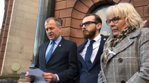 Eleanor Barlow/PA Wire Solicitor Neil Hudgell (l) reading a statement on behalf of Jack and Bernadette Sargeant outside the coroner's court in Ruthin