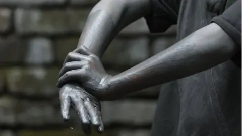 Getty Images A 13-year-old boy washes his hands at an aluminium cooking pot manufacturing factory in India.