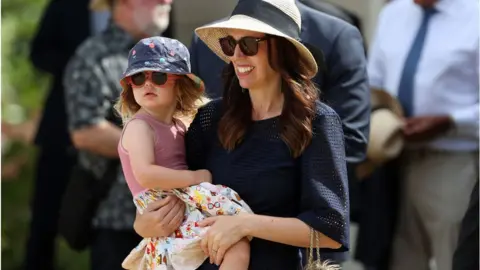 Getty Images Prime Minister Jacinda Ardern arrives at the Waitangi Treaty Grounds with daughter Neve attend Beat the Retreat with the NZ Navy on February 05, 2021 in Waitangi, New Zealand.