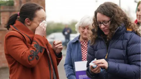 PA Media Rhiannon Davies (left) and Kayleigh Griffiths (right) react