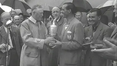 Pathe Max Faulkner is handed the Claret Jug