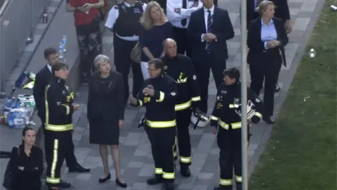 Getty Images Theresa May meets firefighters at the scene