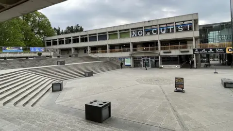 Shaun Whitmore/BBC View of UEA campus with NO CUTS spelled out in large letter across windows