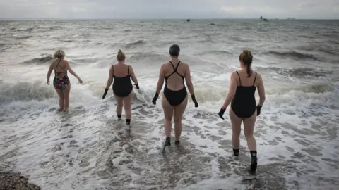 PA Media Women swimming in the sea