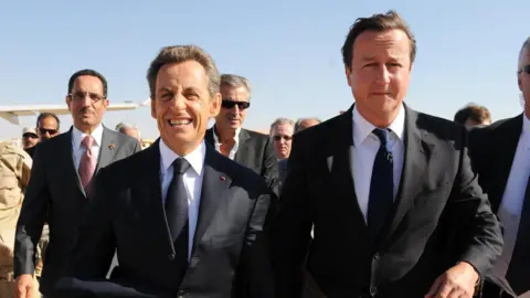 PA Media Nicholas Sarkozy and David Cameron arrive at Benghazi airport, Libya