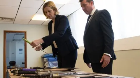 PA Home Secretary Amber Rudd being shown a collection of knives by Superintendent Sean Yates that have been involved in knife crime and recovered by the police in London