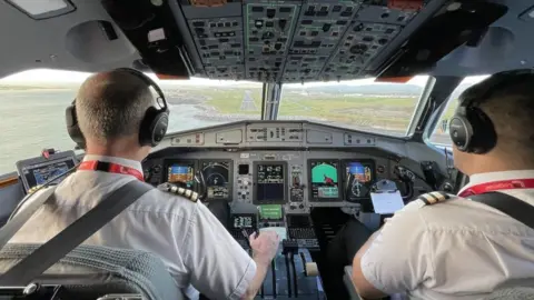 Loganair Loganair pilots in the cockpit coming in to land at Ronaldsway