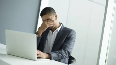 Getty Images Businessman looking frustrated while using a laptop