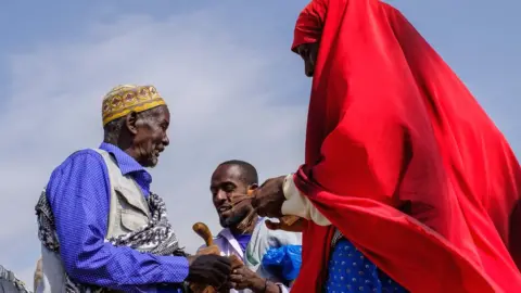 AFP People counting money at a livestock market in Hargeisa, Somaliland - Saturday 18 August 2018