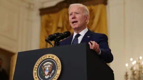 Getty Images Joe Biden speaking at a presidential podium.