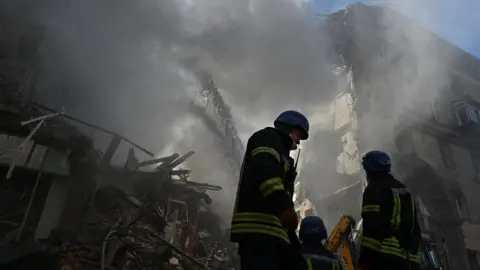 Reuters Rescuers work at the site of a residential building heavily damaged by a Russian missile strike in Zaporizhzhia, Ukraine