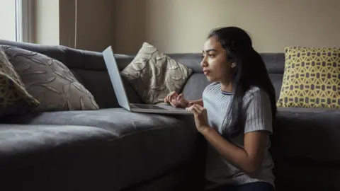 Getty Images Girl using laptop at home