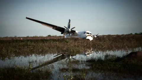 Christina Simons A crashed plane seen amid a flooded landscape in Bentiu, South Sudan