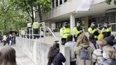 BBC Police outside an Oxford university building, stopping people from entering