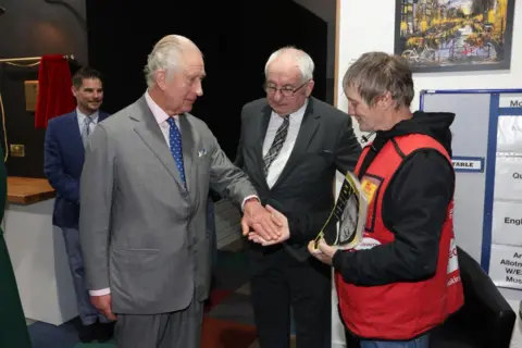 PA Media King Charles III buys a copy of the Big Issue from seller Kelvin along with Lord John Bird, founder of the magazine