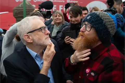 Matthew Horwood / Getty Images A man compares his beard with Jeremy Corbyn