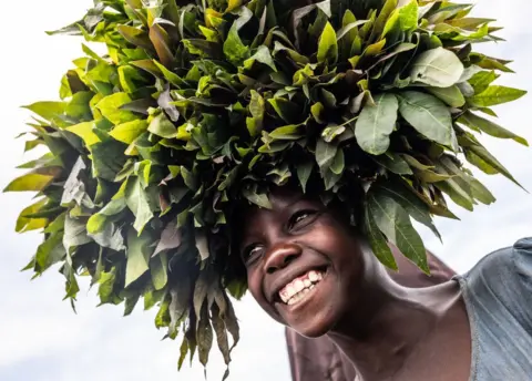 Getty Images A girl selling produce smiles in the Bulengo displacement camp on April 1, 2023 in Goma, Democratic Republic of Congo.