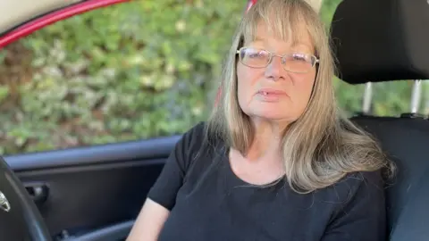 Ben Schofield/BBC Woman sitting in car