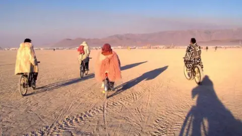 Consuelo Ruiz Four people riding bikes at Burning Man