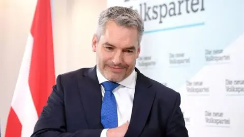 Austria's Interior Minister Karl Nehammer leaves a press conference after he was named as new party head and also as Austria's new chancellor in Vienna on December 3, 2021