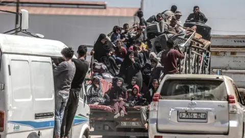 Palestinians cram on to a van after deciding to flee Rafah, as Israeli forces continue a ground operation in the southern Gaza city (8 May 2024)