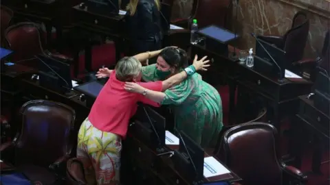 Reuters Two women hug as the senate debates an abortion bill, in Buenos Aires, Argentina, December 30, 2020