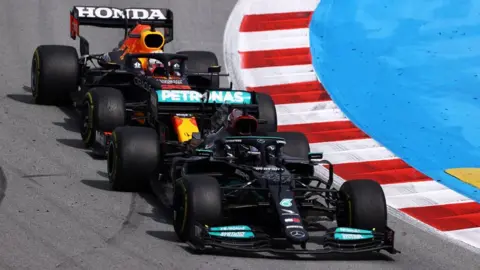 Getty Images Max Verstappen and Lewis Hamilton battling on track