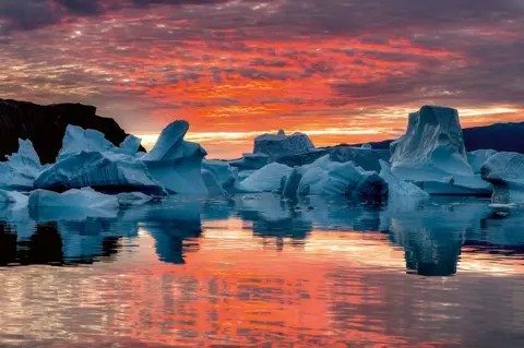 Stefan Forster A sunrise over a number of icebergs