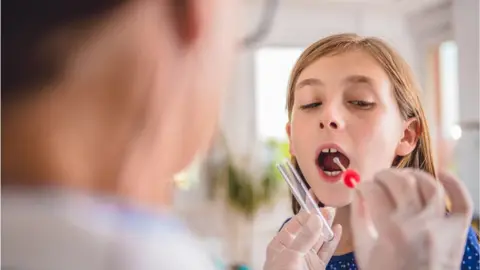 Getty Images Girl having a throat swab