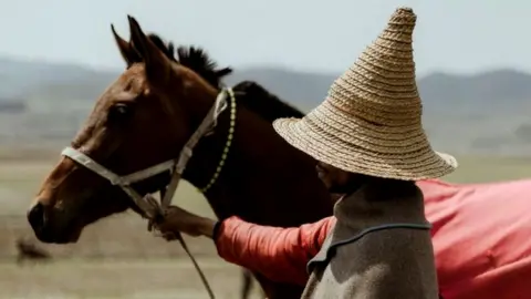 A Lesotho horseman poses with his Basotho pony before competing in a traditional race in Semonkong, a remote town in the Maluti mountains on October 15, 2022. (Photo by MARCO LONGARI / AFP) (Photo by MARCO LONGARI/AFP via Getty Images)