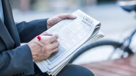 Getty Images Man circles job ads