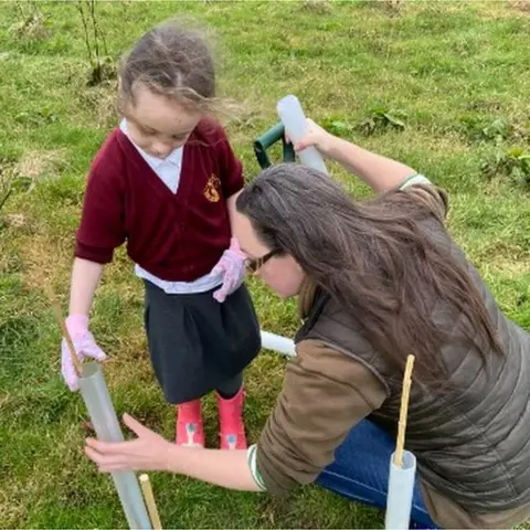 Tristan Faith Kaye Squire and her daughter Willow, planting trees on the farm