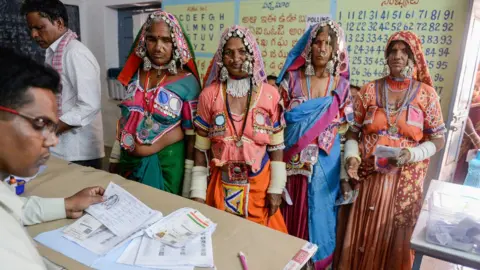 Getty Images An official checks the names of Indian lambadi tribeswomen at a polling station during India's general election at Pedda Shapur village on the outskirts of Hyderabad on April 11, 2019.