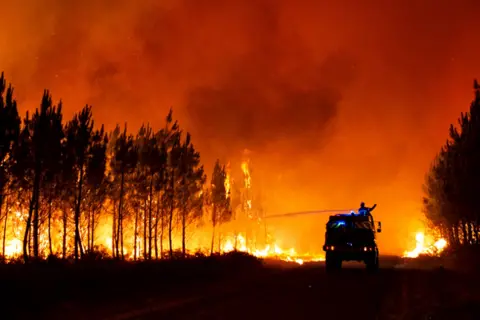 Gironde Firebrigade/EPA-EFE/Shutterstock A handout photo made available by the communication department of the Gironde Fire brigade SDIS33 shows firemen fighting a forest fire in Belin-Beliet, in the Gironde region of southwestern France, 9 August 2022 - issued 10 August 2022.