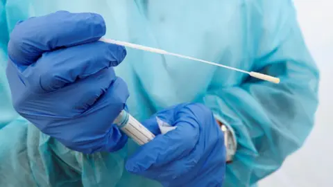 Reuters Staff holding swabbing kit