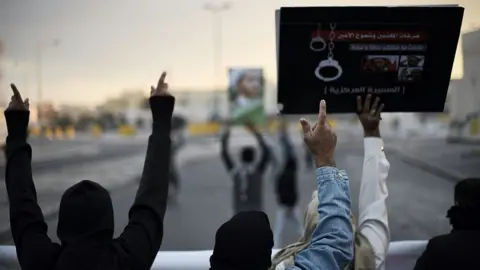 AFP Bahraini protestors hold up placards depicting portraits of Sheikh Ali Salman, leader of Wefaq, during clashes with riot police in Sitra (29 January 2016)