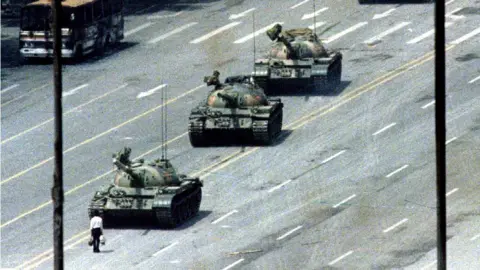 Reuters A man stands in front of three tanks