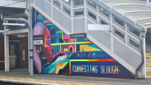 BBC Colourful mural at station that reads "connecting Slough"