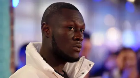 Getty Images Stormzy in a white coat