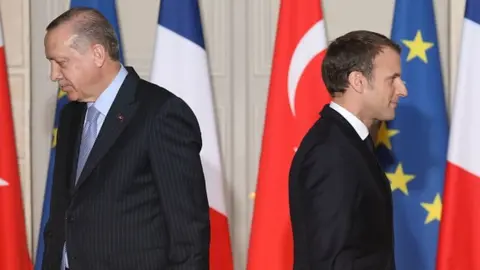 Getty Images Macron and Erdogan walk during a joint press conference at the Elysee Palace in Paris in 2018