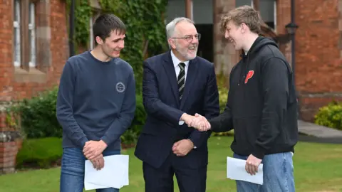 Michael Cooper Campbell College principal Robert Robinson congratulates Patrick Kenny who was awarded four A*/A and (right) Tom Crowther who was awarded three As in their A-levels