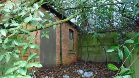 building in overgrown cemetery