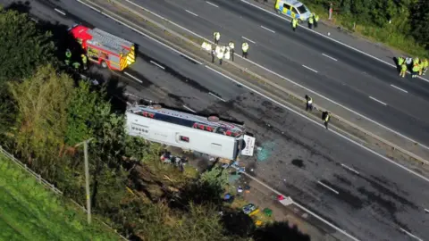 PA Media emergency services around the overturned coach